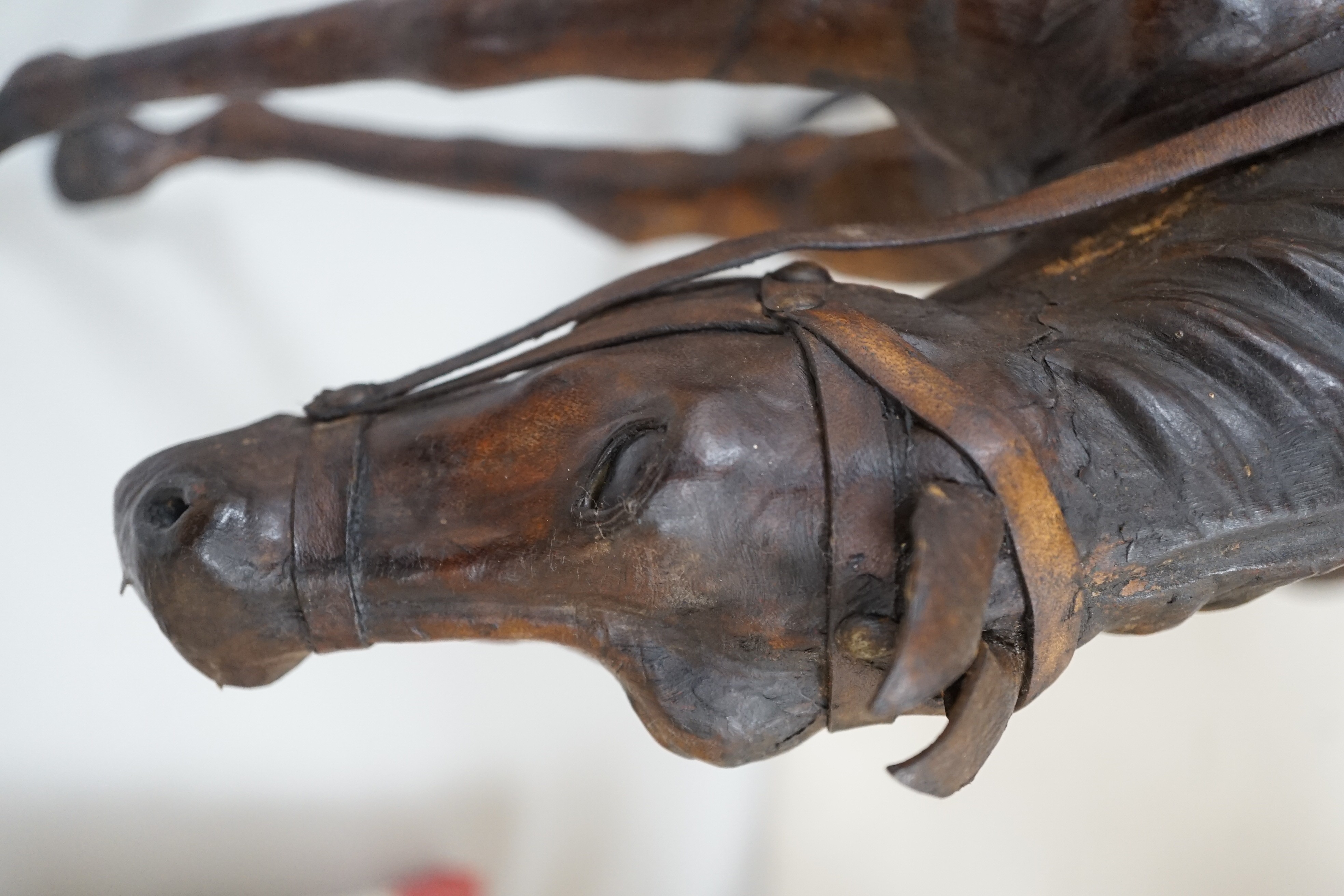 Two finely modelled horses made from brown leather, tallest 49 cms high